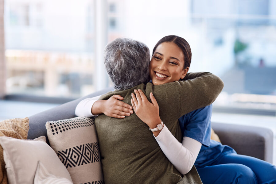 Shot of a young nurse hugging a senior woman.