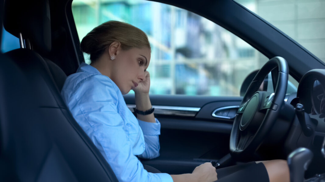 Frustrated businesswoman sitting in car, upset with failure on work, dismissal