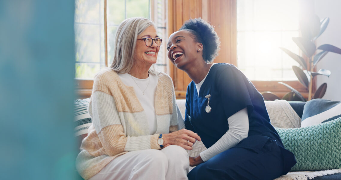 Senior patient, funny or happy caregiver talking for healthcare support at nursing home clinic. Smile, women laughing or nurse speaking of joke to a mature person or woman in a friendly conversation.
