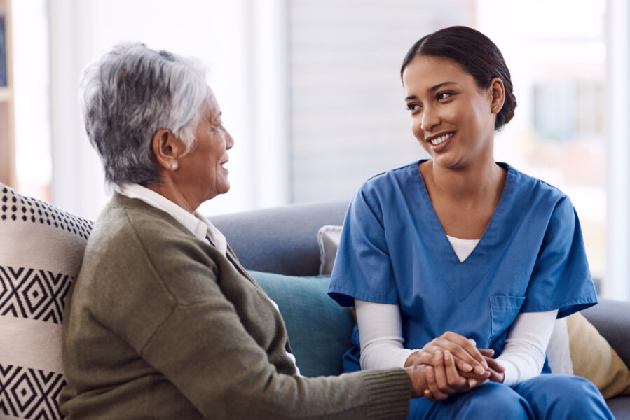 Shot of a young nurse chatting to a senior woman in a retirement home.